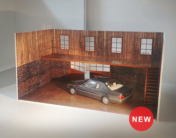 A diorama model kit of a wood and brick two-story garage with a car inside, displaying windows, doors, and a parking base. The model has a realistic design with a 'New' sticker on the bottom right.