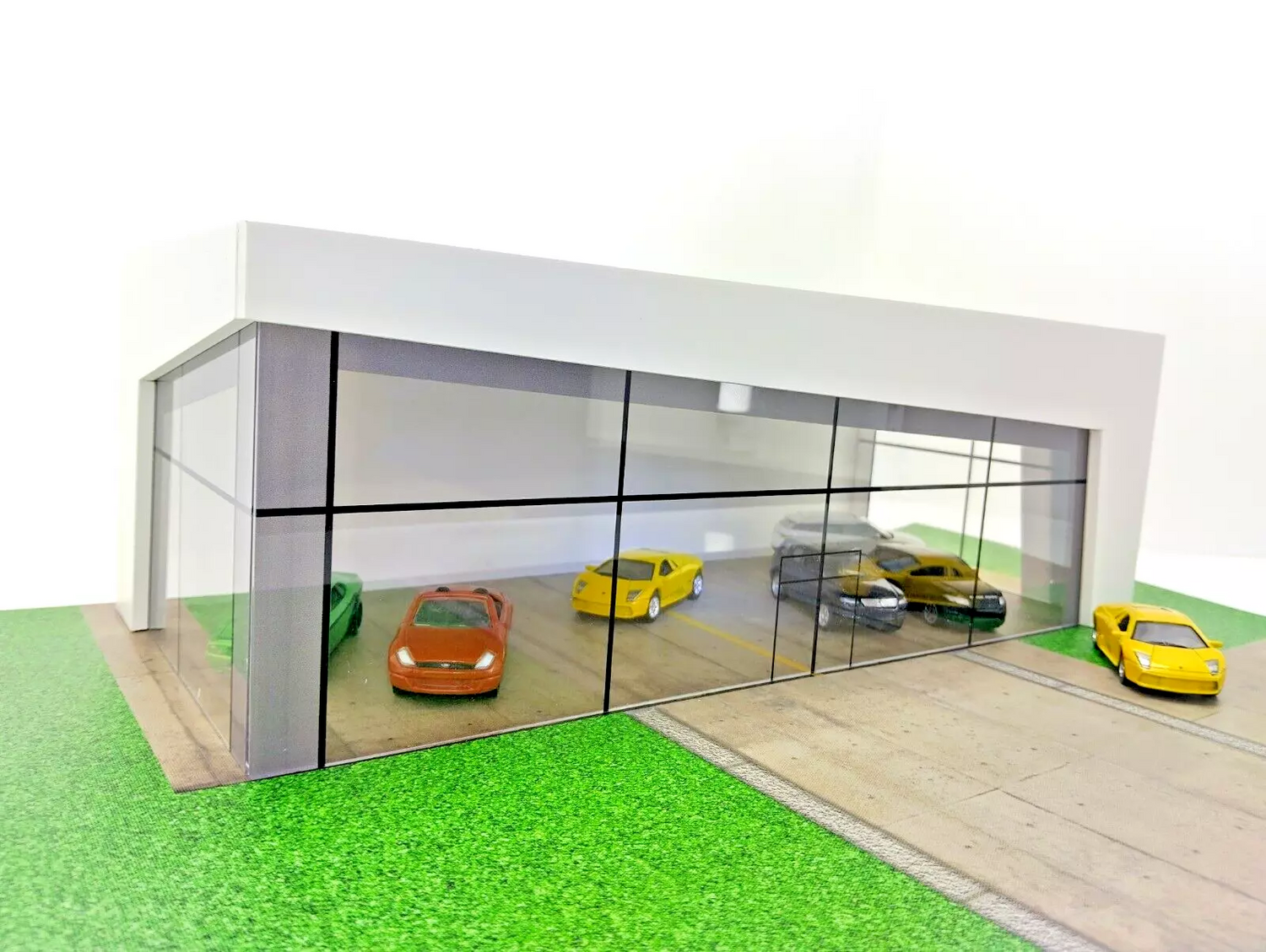 Showroom diorama with model cars displayed for scale