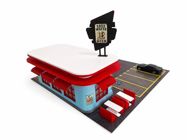 A miniature model of a retro 1960s diner restaurant on a white background. The model features a light blue and red building with a white roof, a black 'Save Water, Drink Beer' sign, a black parking lot with yellow lines, and red-and-white booths.
