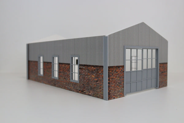 Miniature hangar-style garage with corrugated walls and realistic brick detailing in 1:24 scale