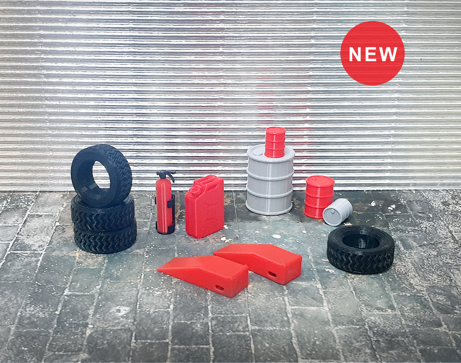 A set of small garage equipment models in 1:24 scale, including tires, stop ramps, a fire extinguisher, an oxygen bottle, a petrol tube, and barrels, displayed on a textured surface with a 'New' sticker on the top left.