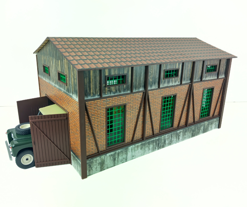 Model of a two-story building with a truck in front on a white background