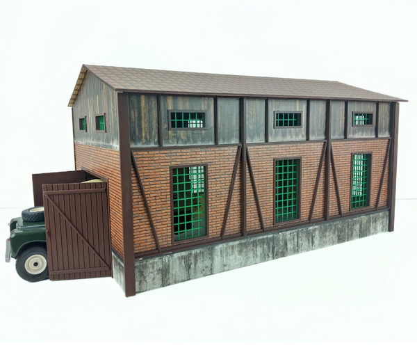 Model of a building with green windows and a truck in front on a white background