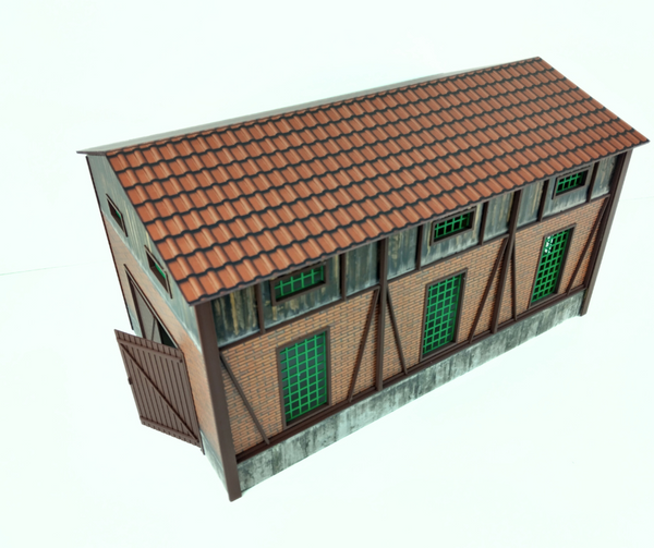 Model of a building with a tiled roof and green windows on a white background