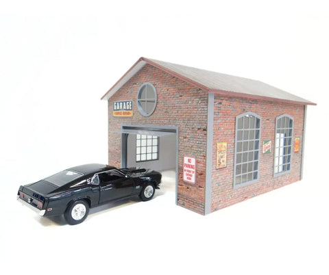 Model of a brick garage with a black car in front on a white background