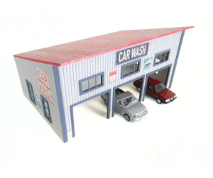 Model car wash building with two cars inside on a white background