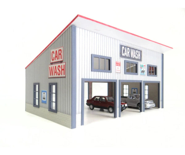 Model of a car wash building with cars in 1/43 scale inside on a white background