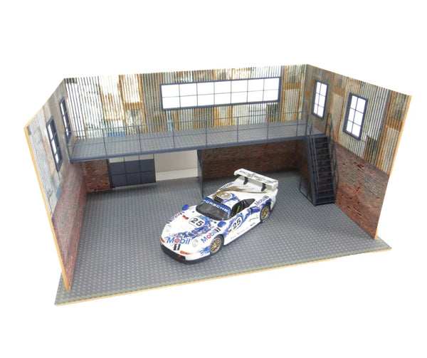 Model car on a detailed garage floor with brick walls and windows.