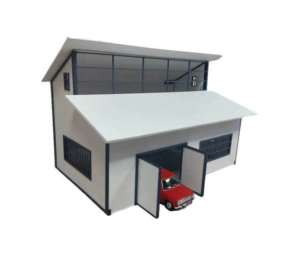 Model of a two-story building with a red car inside the open garage door on a white background