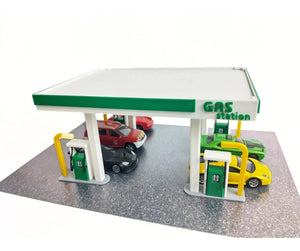 Model gas station with cars on a white background
