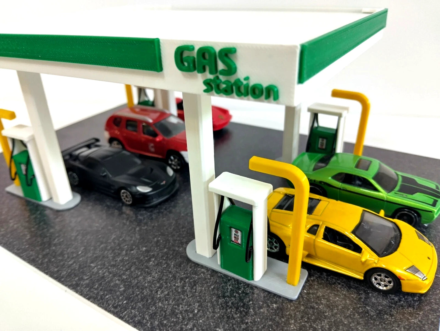 Diorama gas station with cars and pumps on a white background