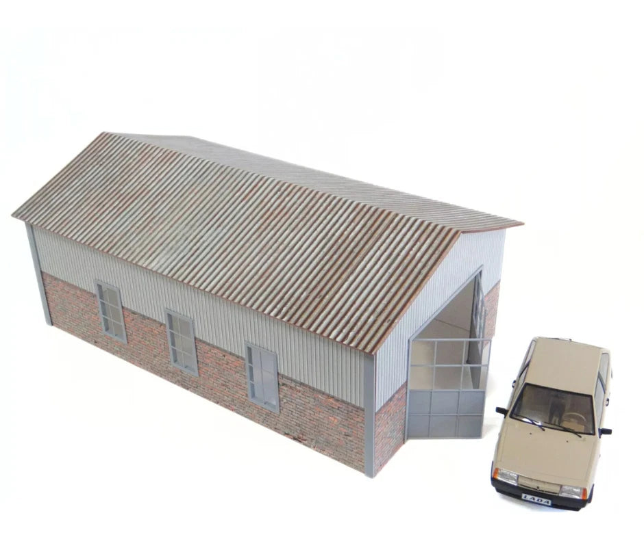 Model of a building with a car parked in front on a white background