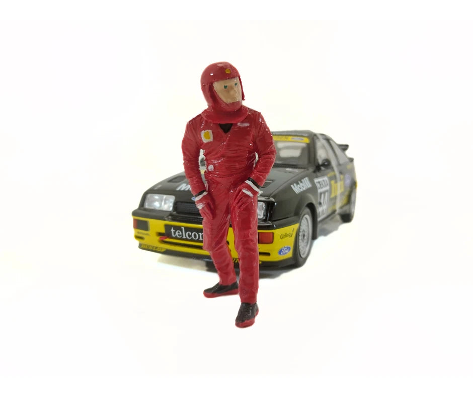 Model of a person in a red racing suit standing next to a car 
