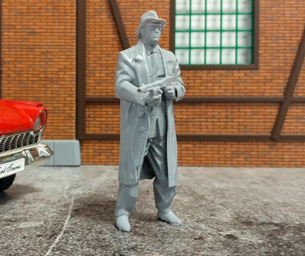 Gray figure in a trench coat standing next to a red car in front of a brick wall.
